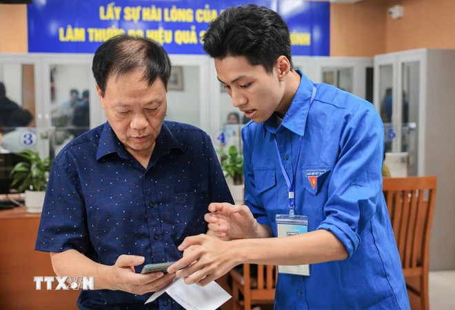 Youth Union members guide people to use and declare online public services on smartphones. (Photo: Hoang Hieu/VNA) ttxvn-chuyen-doi-so-chinh-quyen-2-cap-2.jpg
