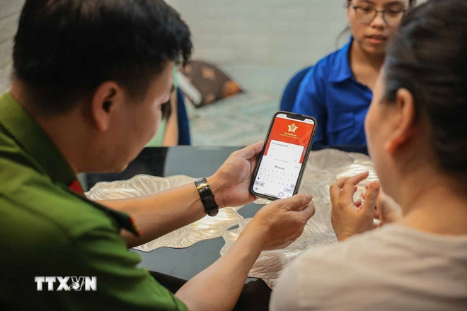 The community digital transformation team guides people to use the digital citizen identification application (VNeID) which can be used to replace traditional documents. (Photo: Hoang Hieu/VNA) ttxvn-chuyen-doi-so-chinh-quyen-2-cap-3.jpg