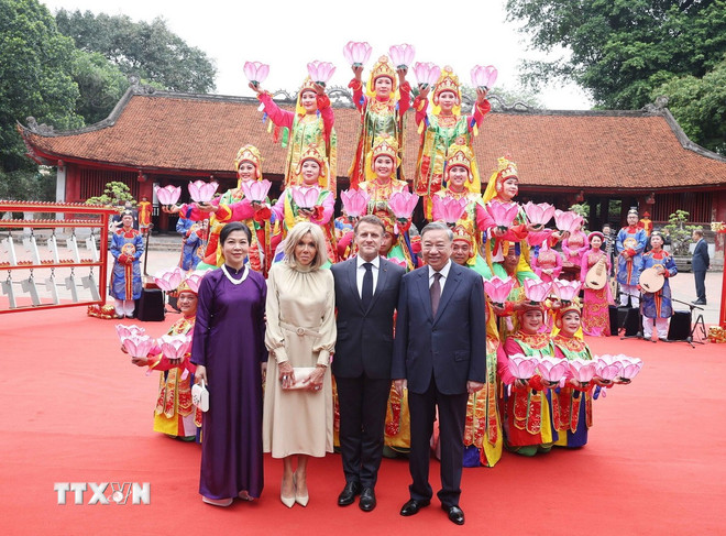 ト・ラム事務総長夫妻、フランスのエマニュエル・マクロン大統領夫妻、そしてフエ宮廷音楽を演奏するアーティストたち。 (写真:トン・ニャット/VNA) ttxvn-tong-bi-thu-to-lam-va-phu-nhan-cung-tong-thong-phap-va-phu-nhan-tham-van-mieu-quoc-tu-giam-4.jpg