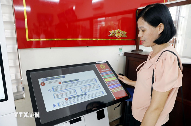 ประชาชนเรียนรู้เกี่ยวกับกระบวนการดำเนินการทางปกครอง ณ ศูนย์บริหารสาธารณะประจำตำบลเจียวมินห์ จังหวัดนิญบิ่ญ (ภาพ: Thai Thuan/VNA) ttxvn-truc-tuyen-toan-trinh.jpg