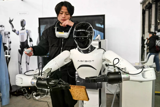 Một người đàn ông điều khiển robot Agibot. (Nguồn: AFP) agibot.jpg