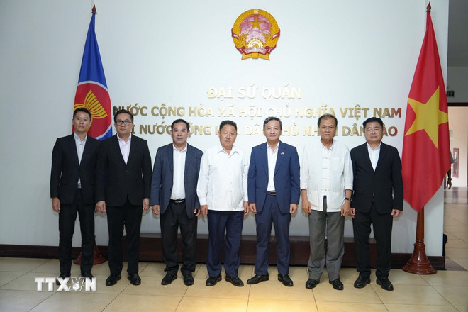 Đại sứ Việt Nam tại Lào Nguyễn Minh Tâm chụp ảnh chung với các đại biểu tham dự sự kiện. (Ảnh: Đỗ Bá Thành/TTXVN) ttxvn-hop-tac-bao-chi-viet-nam-lao-1.jpg