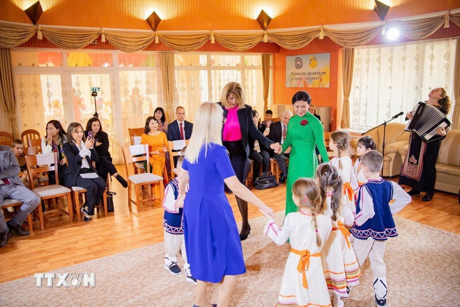İki kadın, çocuklarla el ele tutuşup Bulgar halk dansına katıldı. Neşeli ve masum adımlar, iki kültürü birbirine bağlayan köprüler gibiydi. (Fotoğraf: VNA) ttxvn-phu-nhan-tong-bi-thu-to-lam-tham-truong-mam-non-so-2-zvanche-8.jpg