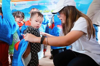 Du khách cùng lữ hành Vietravel vượt núi rừng mang yêu thương đến với trẻ em nghèo Cao Bằng. (Ảnh: CTV/Vietnam+)