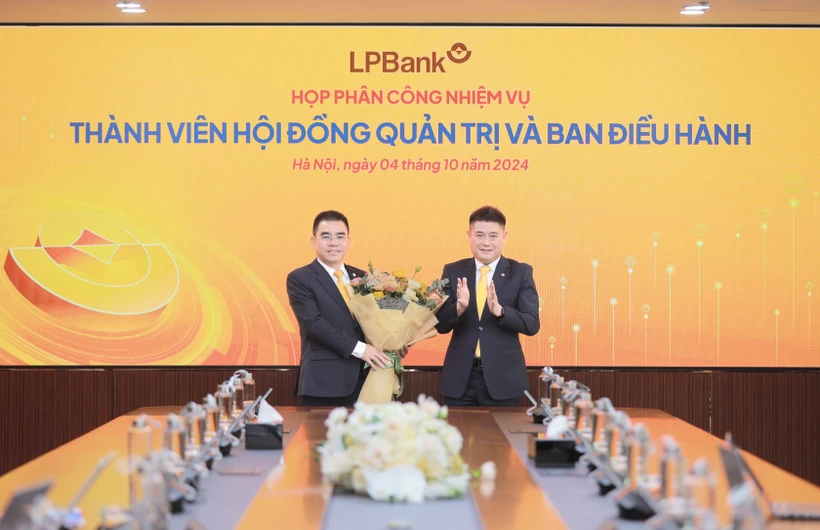 Ông Nguyễn Đức Thụy - Chủ tịch Hội đồng quản trị LPBank (phải) tặng hoa chúc mừng cho ông Hồ Nam Tiến - Phó Chủ tịch thường trực Hội đồng quản trị (trái). (Ảnh: Vietnam+)