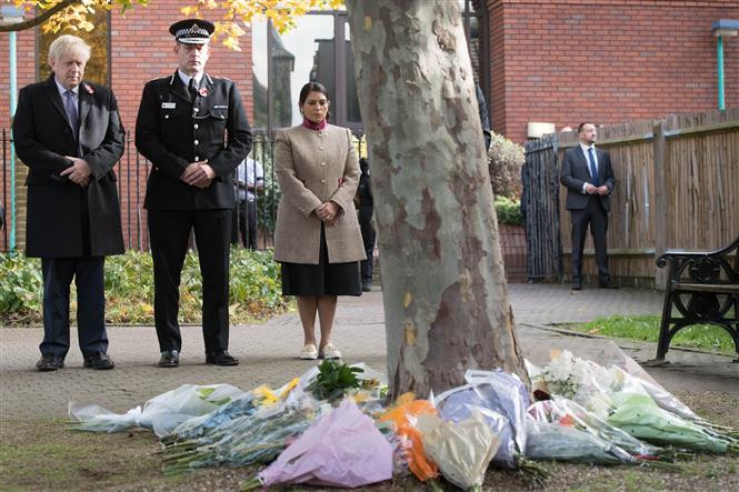 Thủ tướng Anh Boris Johnson, Cảnh sát trưởng hạt Essex Ben-Julian Harrington và Bộ trưởng Nội vụ Anh Priti Patel (phải) tưởng niệm các nạn nhân thiệt mạng trong xe công-ten-nơ được tìm thấy ở thị trấn Grays, hạt Essex, ngày 28/10/2019. (Ảnh: AFP/TTXVN)