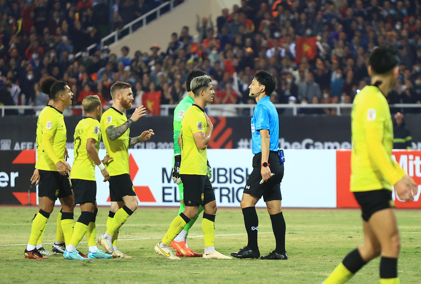 Cầu thủ Malaysia phân trần với trọng tài về tình huống phạm lỗi với Đoàn Văn Hậu. (Ảnh: PV/Vietnam+) 