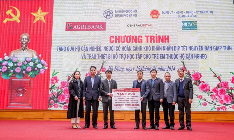 Ông Phạm Đức Ấn - Chủ tịch Hội đồng thành viên Agribank trao tặng quà của Agribank hỗ trợ hộ cận nghèo, đối tượng chính sách quận Hà Đông (Hà Nội) nhân dịp Tết Nguyên đán Giáp Thìn. (Ảnh: Vietnam+)