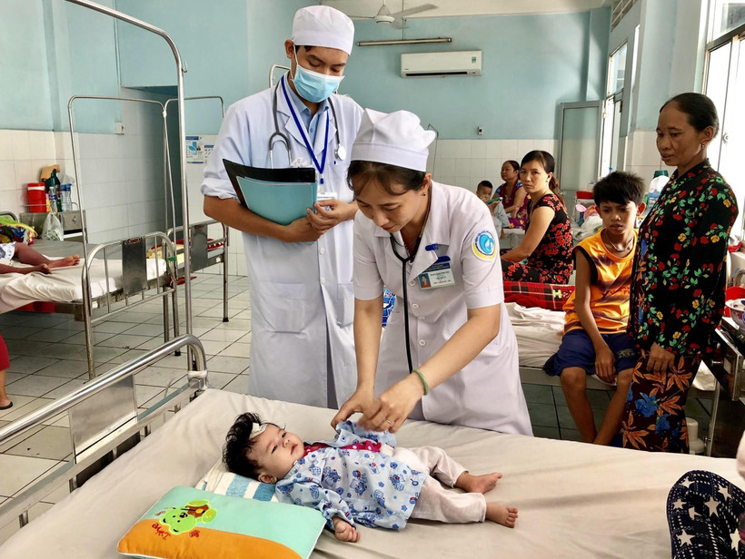 Các bác sĩ Bệnh viện Sản nhi An Giang thăm khám cho một bệnh nhi mắc sốt xuất huyết. (Ảnh: Thanh Sang/TTXVN)