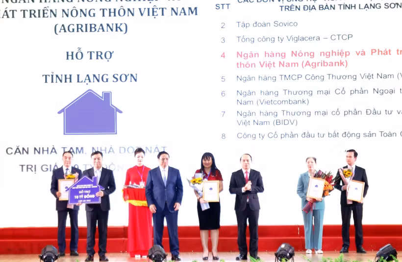 Đại diện Agribank - Đ/c Phùng Thị Bình Phó Tổng Giám đốc (thứ 5 từ trái sang) trao biểu trưng tài trợ 10 tỷ đồng (Ảnh: Vietnam+)