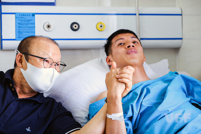 Huấn luyện viên Park Hang-seo nắm chặt tay Đỗ Hùng Dũng trong bệnh viện sáng 25/3. (Ảnh: VFF) 