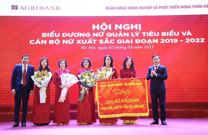 Đảng ủy - Hội đồng thành viên - Ban điều hành Agribank trao tặng Phụ nữ Agribank 8 chữ vàng: Năng động – Sáng tạo – Nhân hậu – Đảm đang. (Ảnh: Vietnam+)