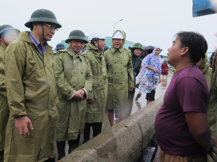 Đồng chí Nguyễn Khắc Định, Bí thư Tỉnh ủy Khánh Hòa ( ở giữa) và đồng chí Nguyễn Đắc Tài, Phó Chủ tịch UBND tỉnh Khánh Hòa thăm hỏi ngư dân đang neo đậu tàu khu tránh trú bão Ninh Hải. (Ảnh: Phan Sáu/TTXVN)