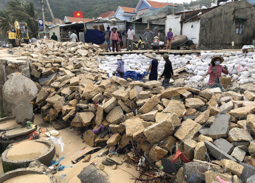 Người dân khẩn trương gia cố tạm kè bờ biển xã Nhơn Hải, thành phố Quy Nhơn, tỉnh Bình Định bị bão số 5 đánh sập gần 100m. (Ảnh: Nguyên Linh/TTXVN)