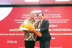 Ông Mai Bá Hùng (phải), Chủ tịch Hội hữu nghị Việt Nam-Indonesia Thành phố Hồ Chí Minh, tặng hoa chúc mừng ông Adiguna Wijaya - Quyền Tổng lãnh sự Cộng hòa Indonesia tại Thành phố Hồ Chí Minh. (Ảnh: Xuân Khu/TTXVN)