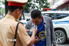 Lực lượng chức năng kiểm tra nồng độ cồn. (Nguồn: TTXVN)