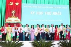 Lãnh đạo Thành ủy, Ủy ban Nhân dân, Ủy ban Mặt trận Tổ quốc Việt Nam tặng hoa chúc mừng lãnh đạo Hội đồng Nhân dân và lãnh đạo các Ban chuyên môn của HĐND thành phố. (Ảnh: Xuân Khu/TTXVN)