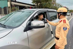 Lực lượng cảnh sát giao thông đo nồng độ cồn người tham gia giao thông trong những ngày nghỉ Tết. (Ảnh: Công Tường/TTXVN)