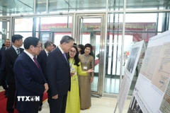 Tổng Bí thư Tô Lâm và Thủ tướng Phạm Minh Chính cùng các đại biểu tham quan trưng bày ảnh về hoạt động của Chính phủ qua các thời kỳ do TTXVN thực hiện. (Ảnh: Thống Nhất/TTXVN)