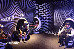 Nghệ sỹ nhiếp ảnh Đoàn Hoài Trung hướng dẫn khách tham quan trải nghiệm công nghệ VR trong Bảo tàng Nhiếp ảnh.