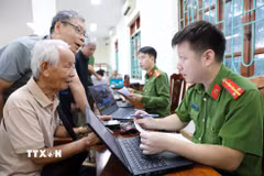 Cán bộ, chiến sỹ phòng PC06 lấy thông tin của thân nhân liệt sỹ tại địa bàn phường Điện Biên Phủ. (Ảnh: Trung Kiên/TTXVN)