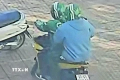 Các đối tượng dùng súng cướp ngân hàng. (Ảnh chụp màn hình camera. TTXVN phát)