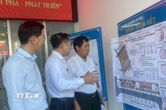 Lãnh đạo Ủy ban Nhân dân phường Tam Thắng thông tin đến người dân các khu vực không phải xin giấy phép xây dựng. (Ảnh: Hoàng Nhị/TTXVN)