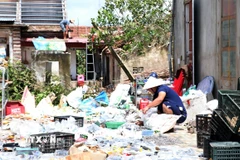 Người dân xã Quỹ Nhất, tỉnh Ninh Bình dọn dẹp đồ đạc sau dông lốc. (Ảnh: Nguyễn Lành/TTXVN)