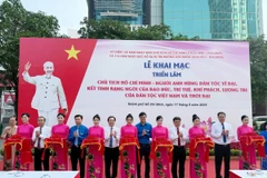 Các đại biểu thực hiện nghi thức khai mạc triển lãm. (Ảnh: Thu Hương/TTXVN)