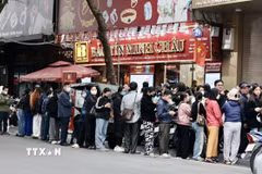 Người dân xếp hàng dài chờ mua vàng tại cửa hàng Bảo Tín Minh Châu trên phố Trần Nhân Tông, Hà Nội, dù có thông báo tạm hết hàng. (Ảnh: Trần Việt/TTXVN)