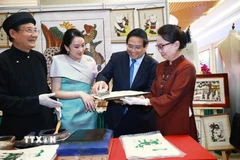 Thủ tướng Phạm Minh Chính và Thủ tướng Vương quốc Thái Lan Paetongtarn Shinawatra trải nghiệm làm tranh dân gian Đông Hồ. (Ảnh: Dương Giang/TTXVN)