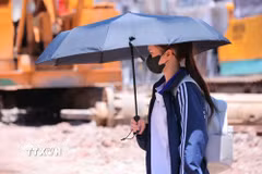 Người dân tìm mọi cách chống nắng khi phải di chuyển trên đường. (Ảnh: Hoàng Hiếu/TTXVN)