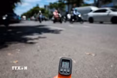 Thiết bị đo nhiệt cho thấy nhiệt độ bề mặt mặt đường ngoài trời lên tới hơn 61 độ C vào thời điểm giữa trưa ngày 25/5. (Ảnh: Phạm Tuấn Anh/TTXVN)
