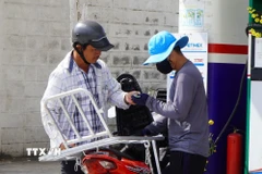 Người dân mua xăng. (Ảnh: Nhựt An/TTXVN)