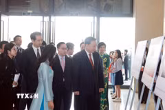 Tổng Bí thư Tô Lâm xem trưng bày ảnh về thành tựu 75 năm quan hệ Việt-Trung, do TTXVN thực hiện. (Ảnh: Thống Nhất/TTXVN)