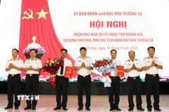 Thượng tá Bùi Xuân Bình, Bí thư Đảng ủy, Chính ủy Vùng 4 Hải quân (giữa) trao Nghị quyết của Thường trực Hội đồng Nhân dân tỉnh Khánh Hòa về việc chỉ định Chủ tịch, Phó Chủ tịch Ủy ban Nhân dân Đặc khu Trường Sa nhiệm kỳ 2021-2026. (Ảnh: TTXVN phát)