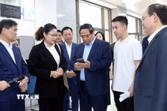 Thủ tướng Phạm Minh Chính ghi nhận đánh giá chất lượng dịch vụ công từ người dân. (Ảnh: Văn Đức/TTXVN)