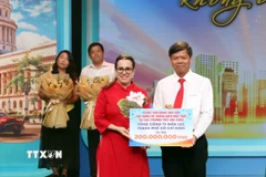 Tổng lãnh sự Cuba tại Thành phố Hồ Chí Minh Ariadne Feo Labrada (trái) tiếp nhận bảng tượng trưng ủng hộ của các đơn vị, nhà tài trợ. (Ảnh: Xuân Khu/TTXVN)