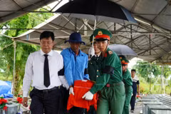 Bí thư Tỉnh ủy Kiên Giang Nguyễn Tiến Hải đưa hài cốt liệt sỹ về nơi an táng. (Ảnh: Văn Sĩ/TTXVN)