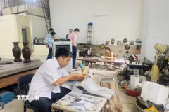 Nghệ nhân làng nghề Chuyên Mỹ đam mê tạo ra những tác phẩm khảm trai sơn mài và giữ ngọn lửa nghề cho quê hương. (Ảnh: Tuyết Mai/TTXVN)