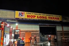 Lực lượng chức năng triển khai chữa cháy tại hiện trường vụ hỏa hoạn. (Ảnh: TTXVN phát)
