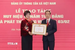 Bà Vũ Việt Trang, Ủy viên Ban Chấp hành Đảng bộ Khối các cơ quan Trung ương, Bí thư Đảng ủy, Tổng Giám đốc Thông tấn xã Việt Nam trao Huy hiệu 40 năm tuổi Đảng cho ông Thân Văn Hạnh. (Ảnh: Phương Hoa/TTXVN)