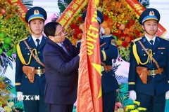 Thủ tướng Phạm Minh Chính gắn Danh hiệu Anh hùng Lực lượng Vũ trang Nhân dân lên Quân kỳ Quyết thắng của Quân chủng Phòng không-Không quân. (Ảnh: Dương Giang/TTXVN)