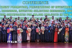 Phó Thủ tướng Thường trực Chính phủ Nguyễn Hòa Bình, chụp ảnh chung với các nhà đầu tư. (Ảnh: Danh Lam/TTXVN)