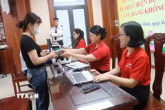 Các hộ dân đến nhận tiền thưởng do bàn giao mặt bằng sớm Dự án Cảng hàng không Quốc tế Gia Bình. (Ảnh: Thanh Thương/ TTXVN)