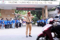 Cán bộ, chiến sỹ Đội Cảnh sát giao thông số 7 điều tiết, phân luồng giao thông tại điểm thi Trường Trung học cơ sở Nguyễn Trãi (quận Thanh Xuân, Hà Nội). (Ảnh: Phạm Kiên/TTXVN)
