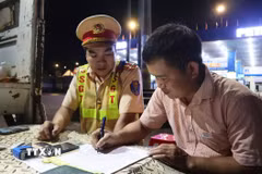 Lực lượng Cảnh sát giao thông trạm Đồng Phú lập biên bản, xử lý xe khách vi phạm giao thông. (Ảnh: Đậu Tất Thành/TTXVN)