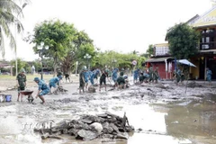 Bộ Chỉ huy Quân sự thành phố Đà Nẵng triển khai hơn 100 cán bộ, chiến sỹ cùng phương tiện, máy móc cơ giới và trang bị tẩy rửa, khẩn trương cơ động vào khu vực phố cổ Hội An giúp chính quyền và nhân dân làm sạch, thu gom rác thải, tẩy rửa môi trường. (Ảnh: Trần Tĩnh/TTXVN)