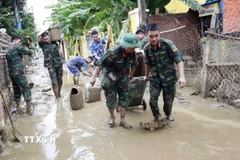 Tuyến Quốc lộ 40B bị sạt lở nặng, tuyến đường nối từ vùng đồng bằng về nhiều khu vực miền núi bị đình trệ hoàn toàn, hàng hóa tiếp tục được vận chuyển bằng sức người. (Ảnh: Đoàn Hữu Trung/TTXVN)