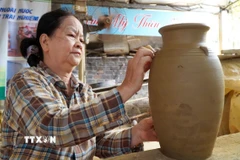 Nghệ nhân tạo hình sản phẩm gốm truyền thống từ nguyên liệu đất sét. (Ảnh: Lê Phước Ngọc/TTXVN)